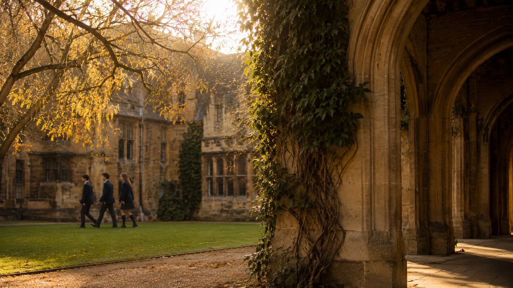 Traditional English independent school courtyard in autumn afternoon light, stone archway and ivy, students in school blazers