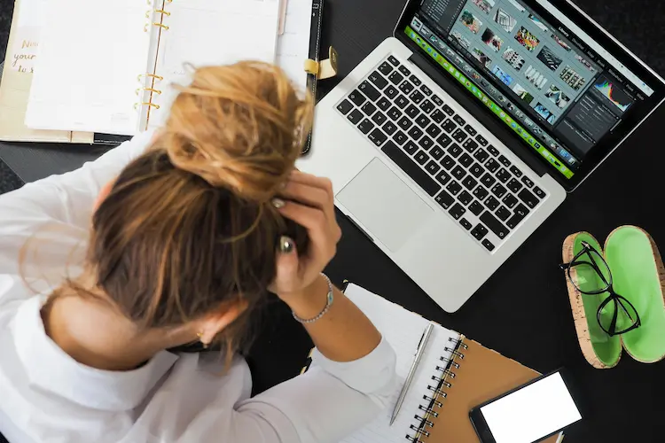 Stressed student at messy desk surrounded by notes